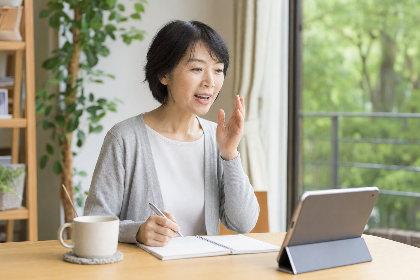 自宅でタブレットを使い短い英語を声に出して練習する大人の女性