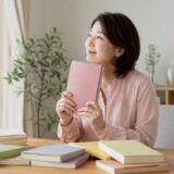 複数の教材から学び直しに使う一冊を選ぶ大人の女性