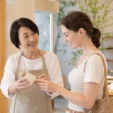 外国人のお客様へ商品を説明する大人女性スタッフ