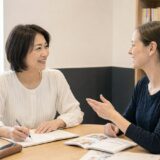 英会話教室で外国人講師のマンツーマンレッスンを受ける大人の女性