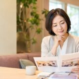 英会話教室の乗り換えを検討し、資料を比較する大人女性