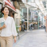 高円寺の商店街を英語学習ノートを持って歩く大人女性
