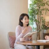 外国人講師と一対一で英会話を練習する大人の女性