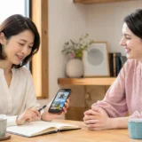 スマートフォンの写真を見ながら最近の出来事を英語で話す準備をする大人女性