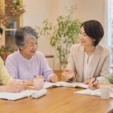 英会話サークルや教室で仲間と英語を学ぶシニア女性