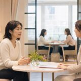 英会話教室のスタッフに講師との相性について相談する大人女性