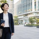虎ノ門ヒルズ周辺のビジネス街を英語学習ノートを持って歩く大人女性