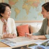 旅行日程を見ながら外国人講師と旅行英会話を練習する大人女性