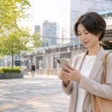 上野駅近くで銀座の英会話教室への経路を確認する大人女性