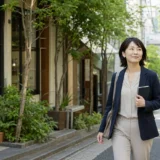 代々木八幡の緑ある落ち着いた街をノートを持って歩く大人女性
