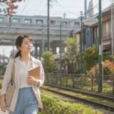 荒川区の街並みと路面電車沿いを歩き英会話教室を検討する大人女性