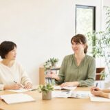 少人数の英会話グループレッスンで講師と大人の受講者が会話する様子