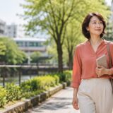 目黒区の緑豊かな街並みを歩く英会話学習中の大人女性