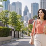 新宿区の街並みを歩く英会話学習中の大人女性