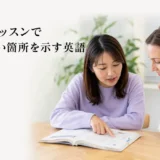 英会話レッスンで教科書の分からない箇所を指し示す大人女性