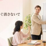 英会話講師がホワイトボードを消す前に待ってほしいと合図する大人の女性